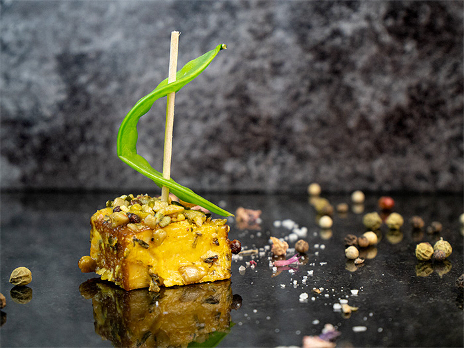 Tofu mariniert mit Kräutern und Kernen, dekoriert mit einem Segel aus einer Zuckerschote